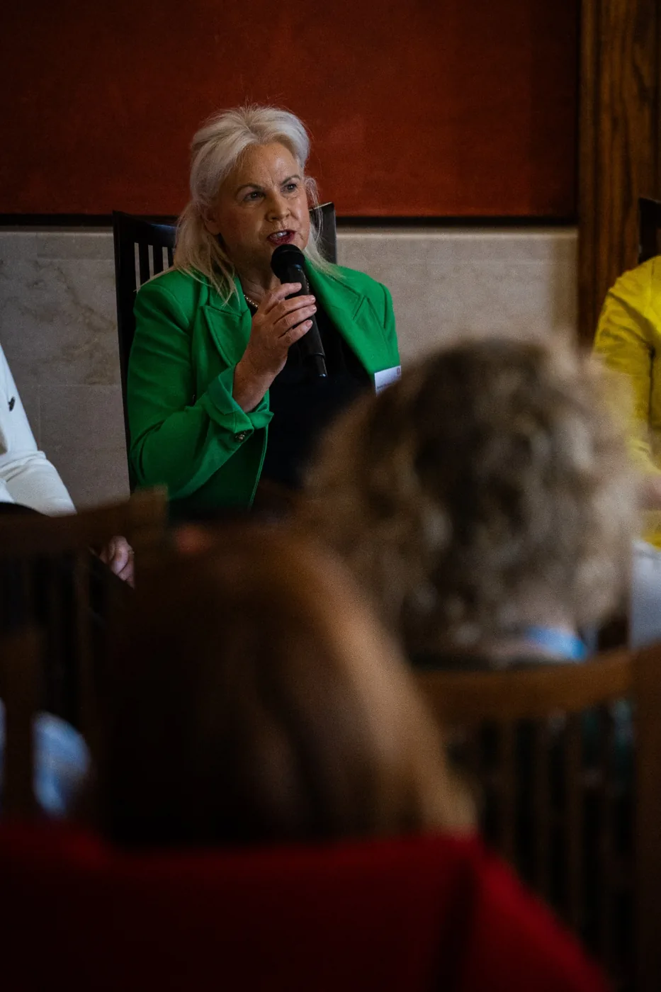 Speaker in green addressing the room